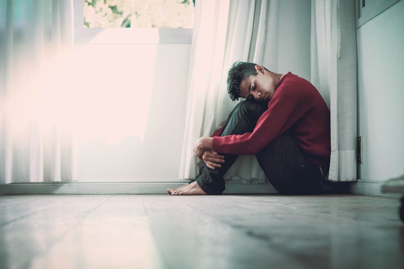 Man feeling anxious sitting on the floor